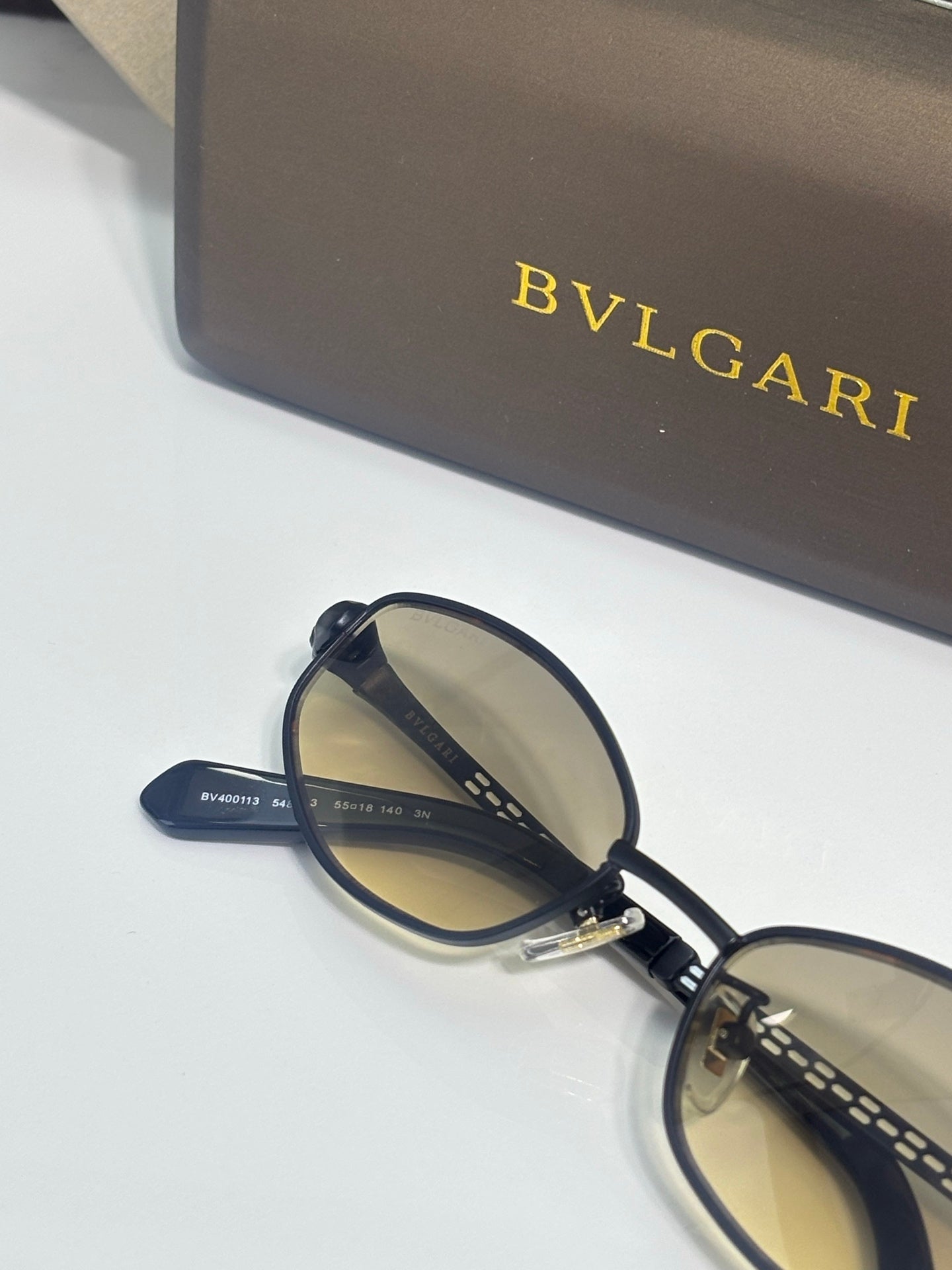 Oval sunglasses with dark blue round frames and engraved temple arms