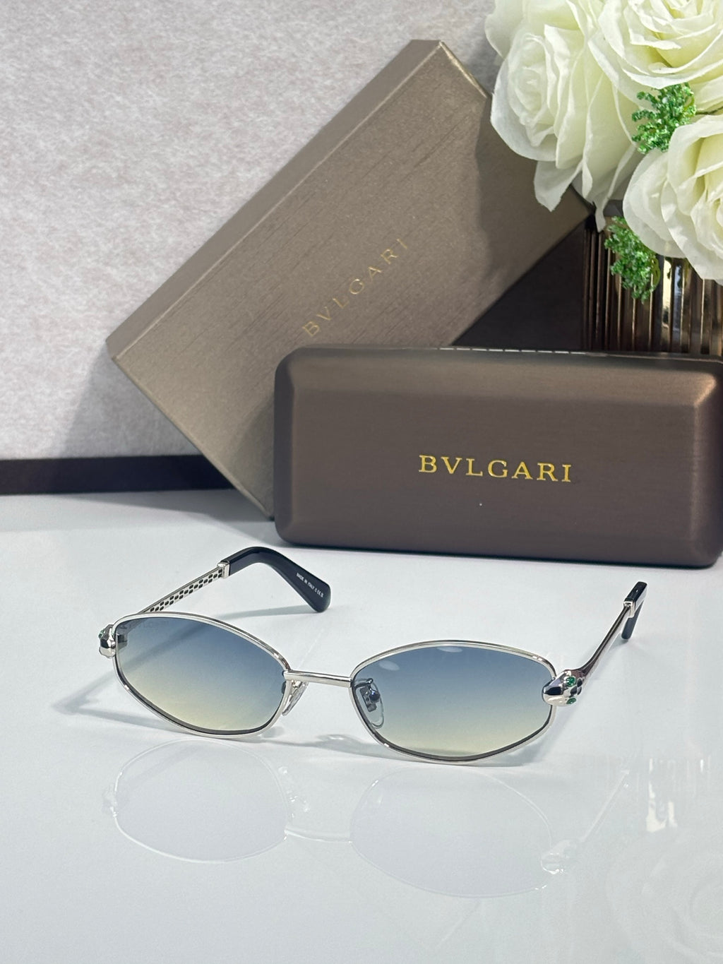 Silver-tone oval sunglasses with dark blue lenses and slim metal arms