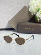 Bvlgari glasses with gold round frames, dark brown lenses, and dark temples