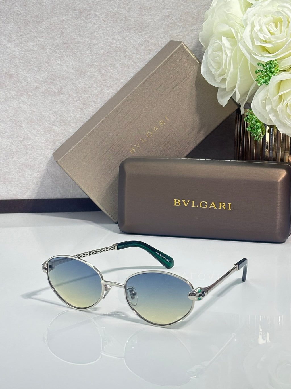 Bvlgari glasses with silver round frames, blue gradient lenses, and green temple tips