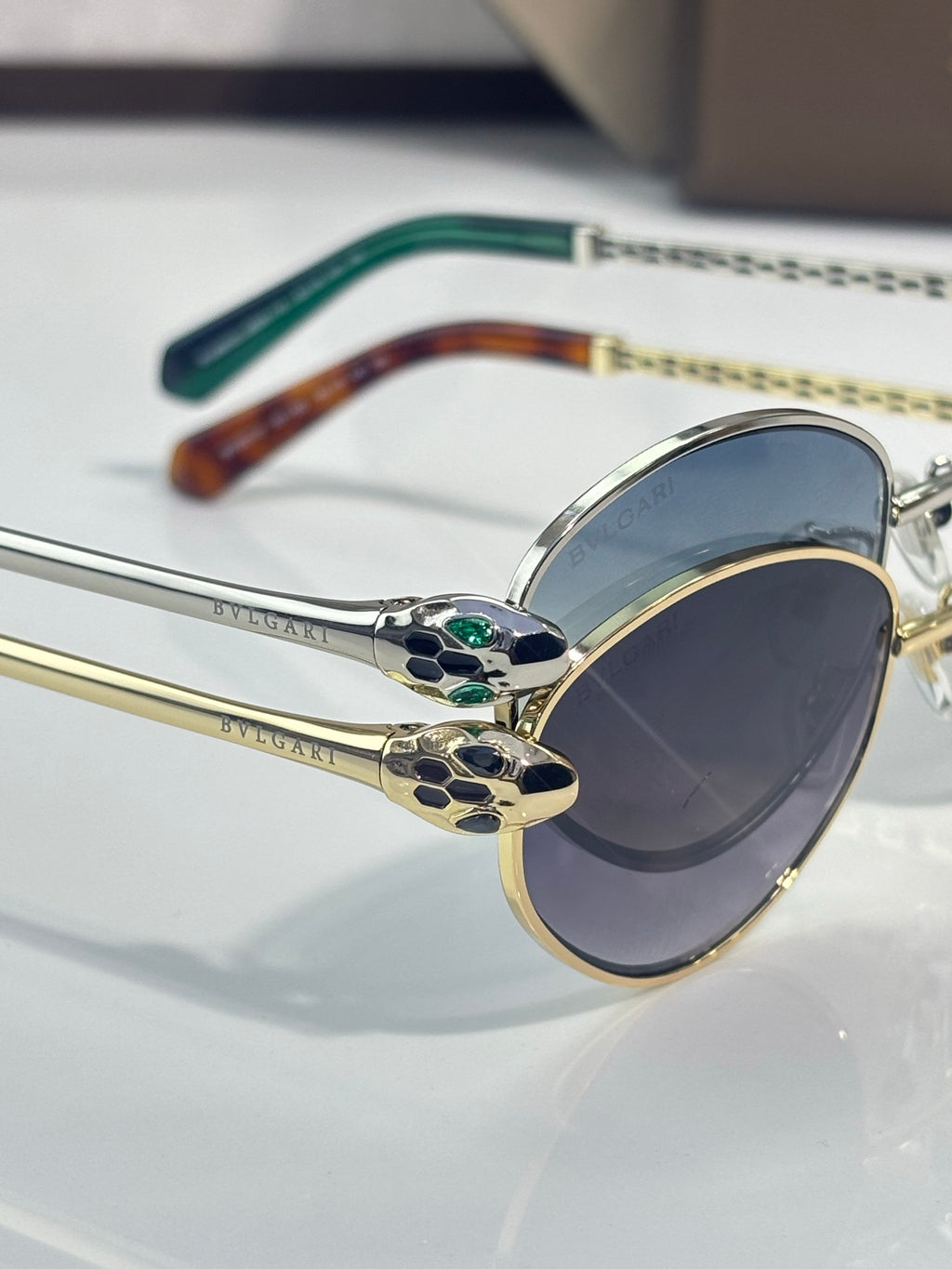 Bvlgari glasses with gold round frames, blue gradient lenses, and patterned bridge