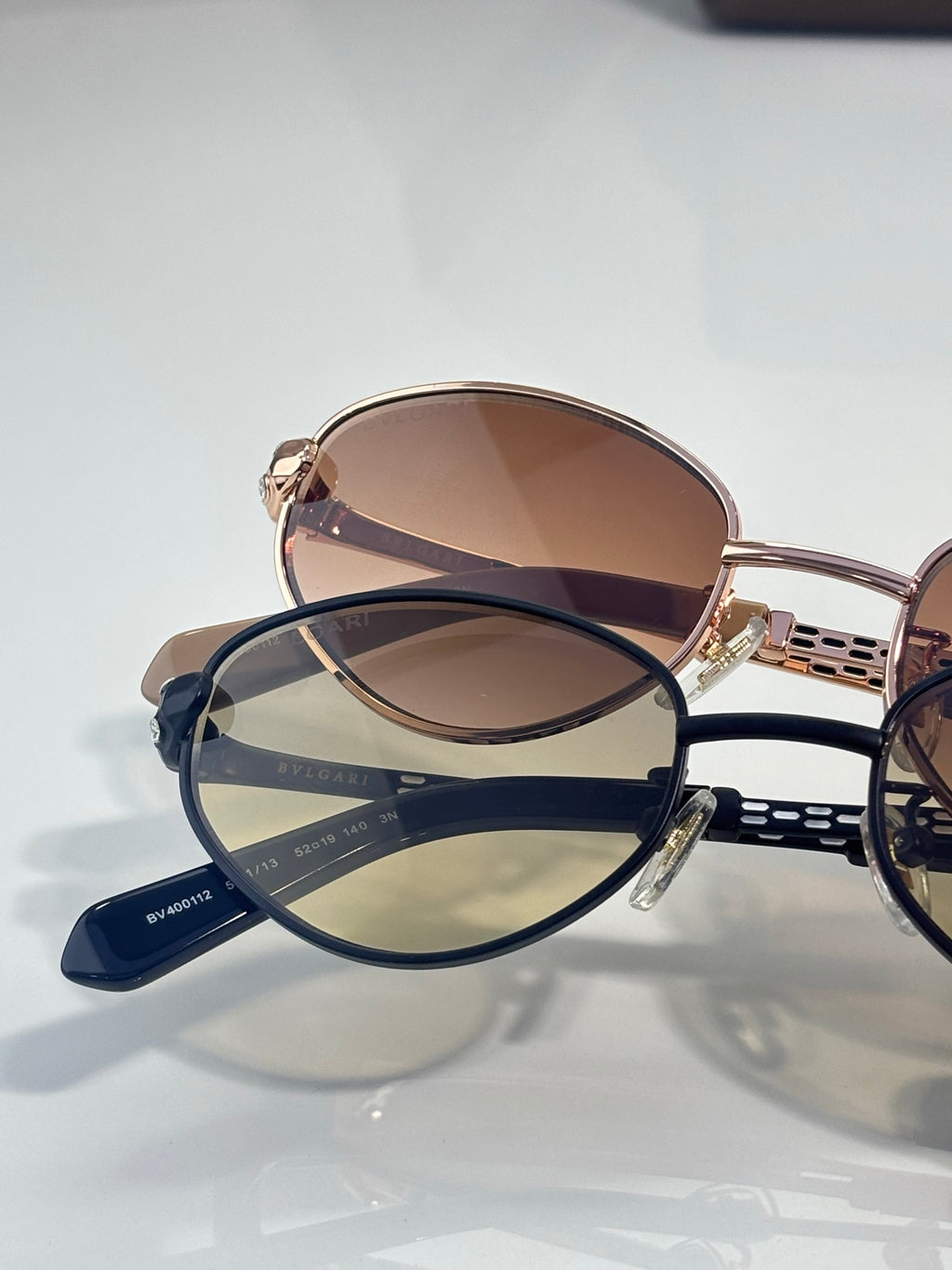 Round sunglasses: one rose-gold with brown lenses, one navy with blue lenses