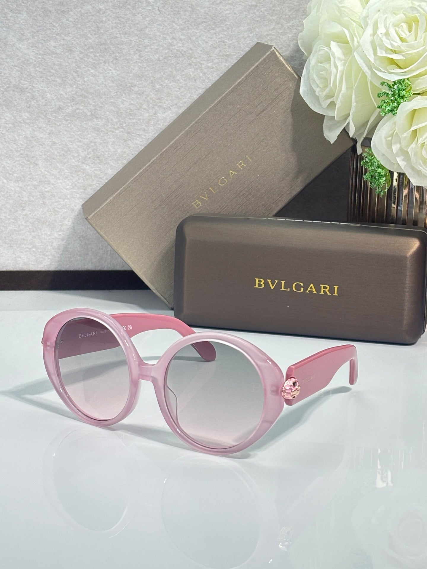 Round sunglasses with pink frames and light tan-tinted lenses