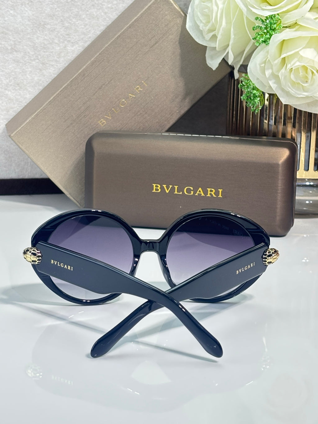Round sunglasses with dark blue frames and dark purple-tinted lenses