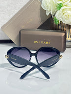 Round sunglasses with dark blue frames and dark purple-tinted lenses