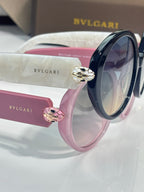 Round sunglasses with glossy pink and black frames and decorative side charms