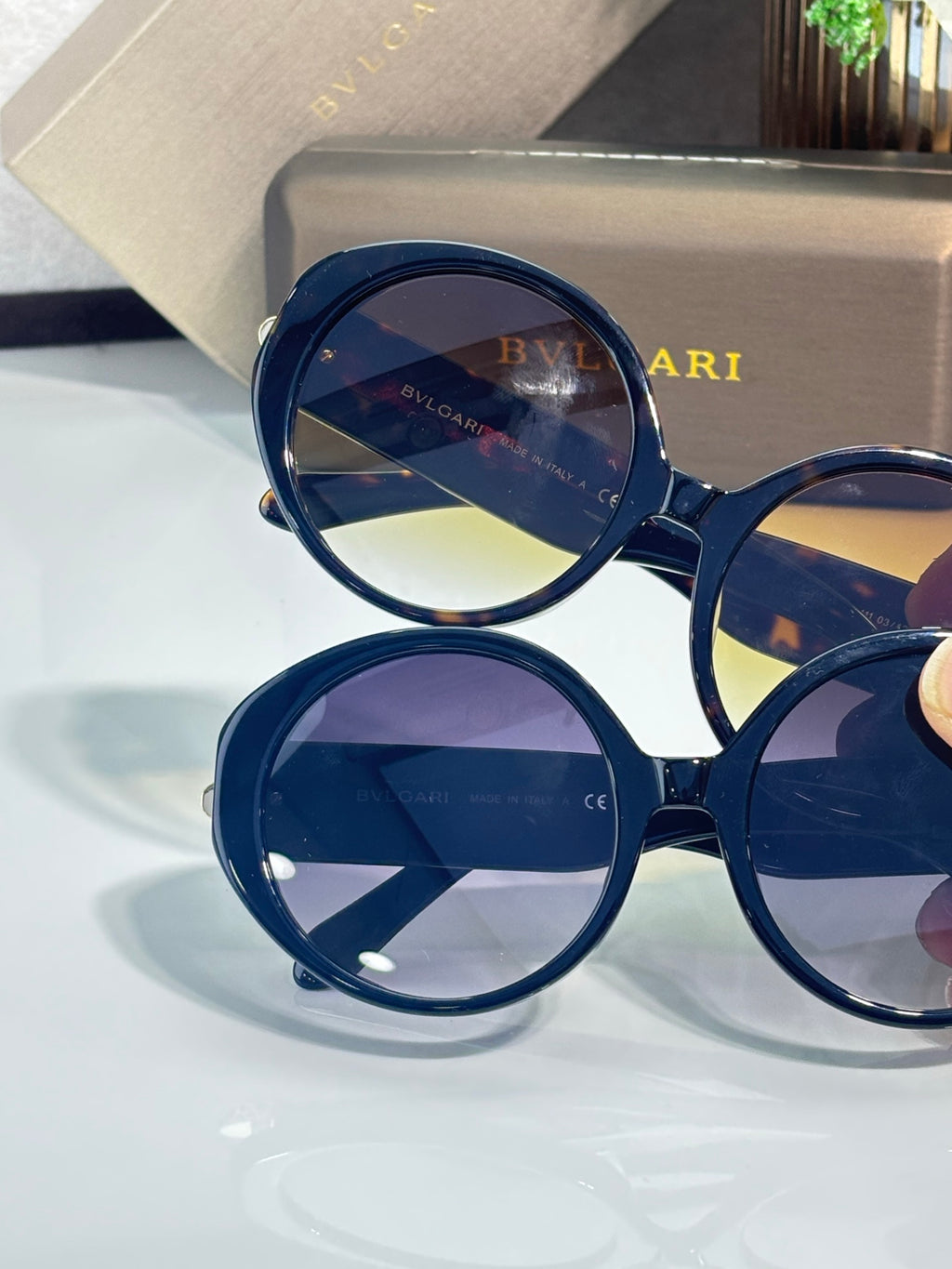 Round sunglasses with dark blue frames and layered blue-tinted lenses