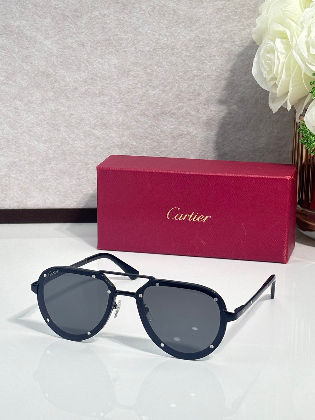 Cartier sunglasses with navy-and-gold frame and dark blue lenses, front view