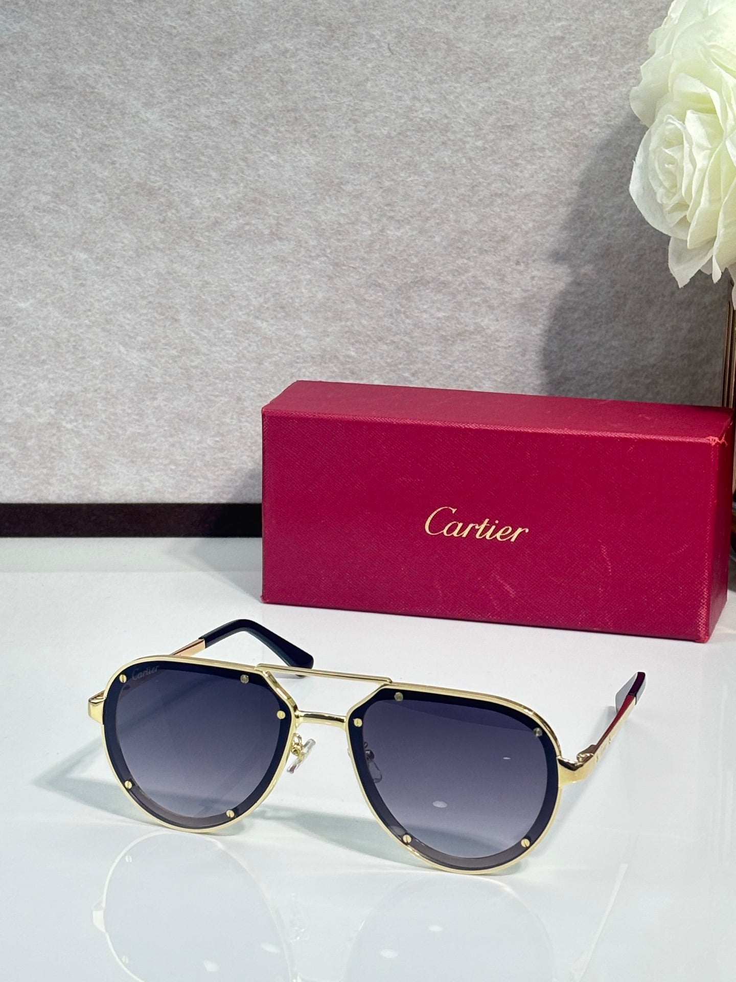 Cartier sunglasses with gold frame and dark blue lenses, angled front