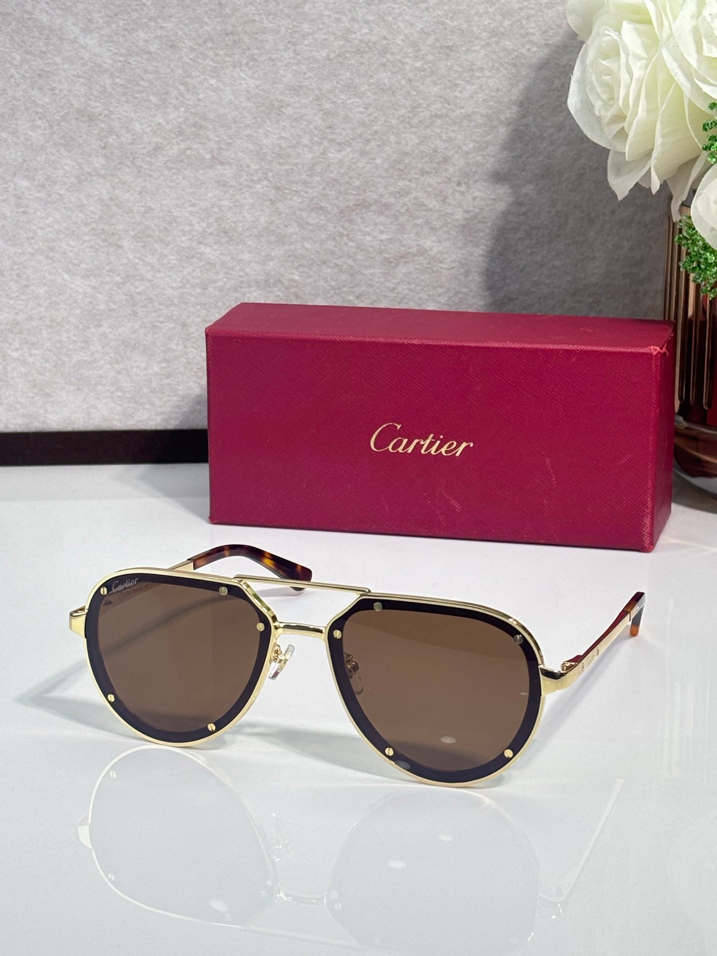 Cartier sunglasses with gold frame and brown lenses, cat-eye shape