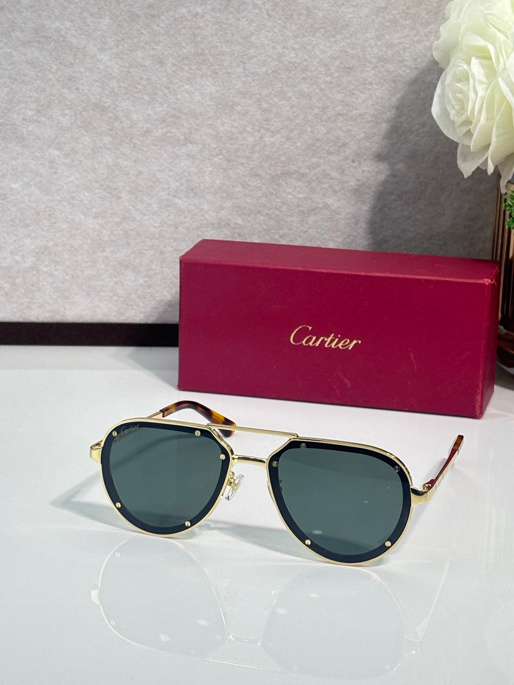 Cartier sunglasses with gold frame and dark green lenses, cat-eye shape