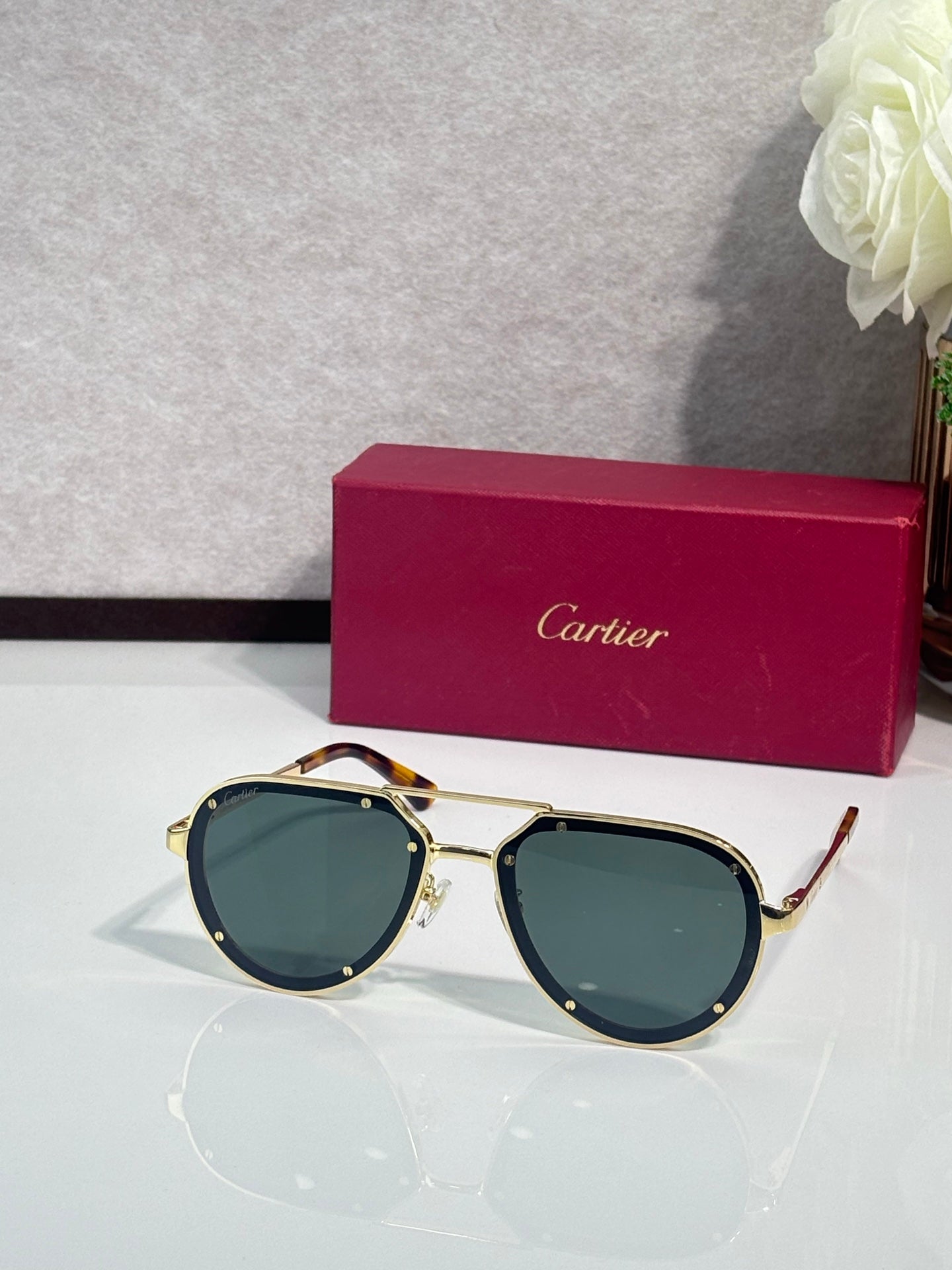 Cartier sunglasses with gold frame and dark green lenses, cat-eye shape