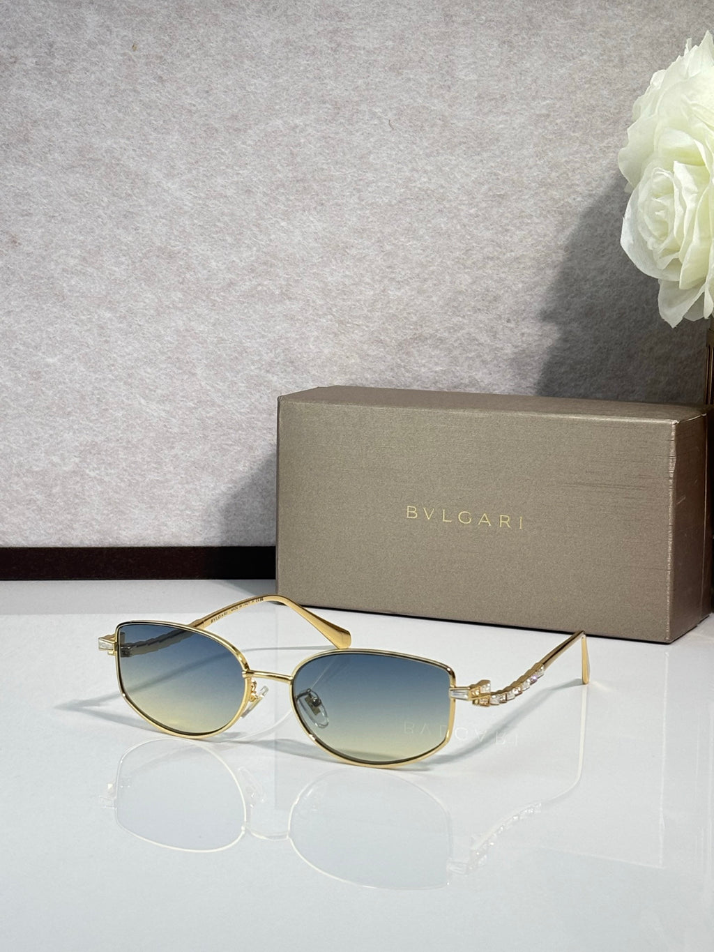 Bvlgari sunglasses with gold frame and teal blue lenses