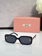 MiuMiu dark sunglasses with black frames and dark lenses, angular temples