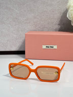 MiuMiu orange sunglasses with tinted lenses and gold logo detail on temple