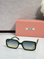 MiuMiu green sunglasses with tinted lenses and gold logo at temple