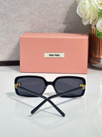 MiuMiu navy sunglasses with dark lenses and gold logo on temple, folded