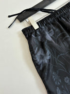 Gucci floral print shorts close-up, dark fabric with elastic waistband