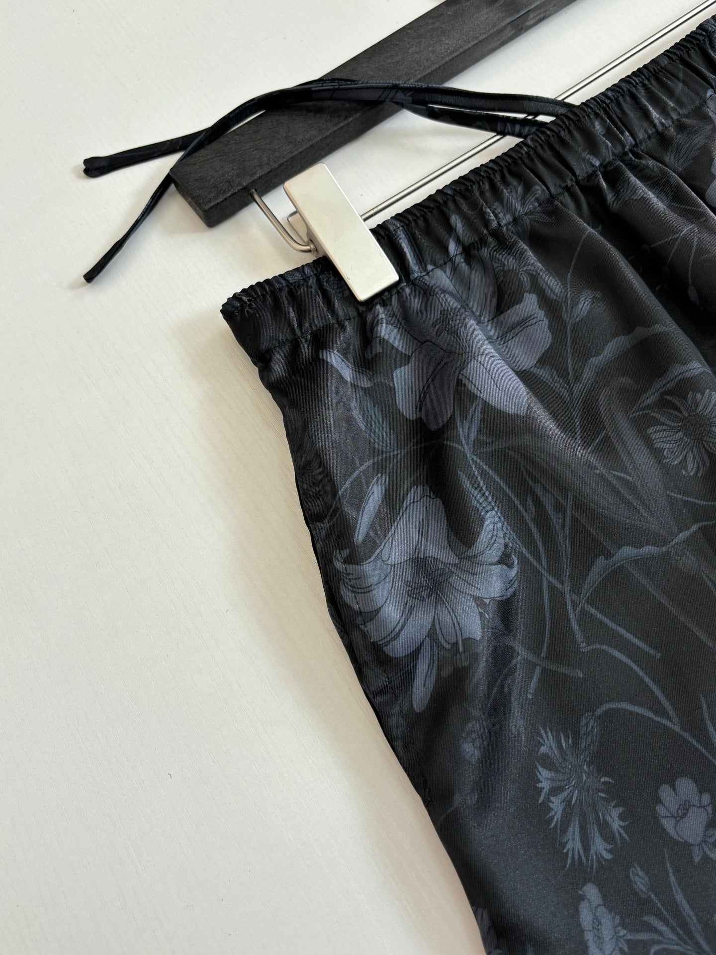 Gucci floral print shorts close-up, dark fabric with elastic waistband