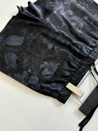 Gucci shorts fabric close-up, dark floral print with elastic cuff