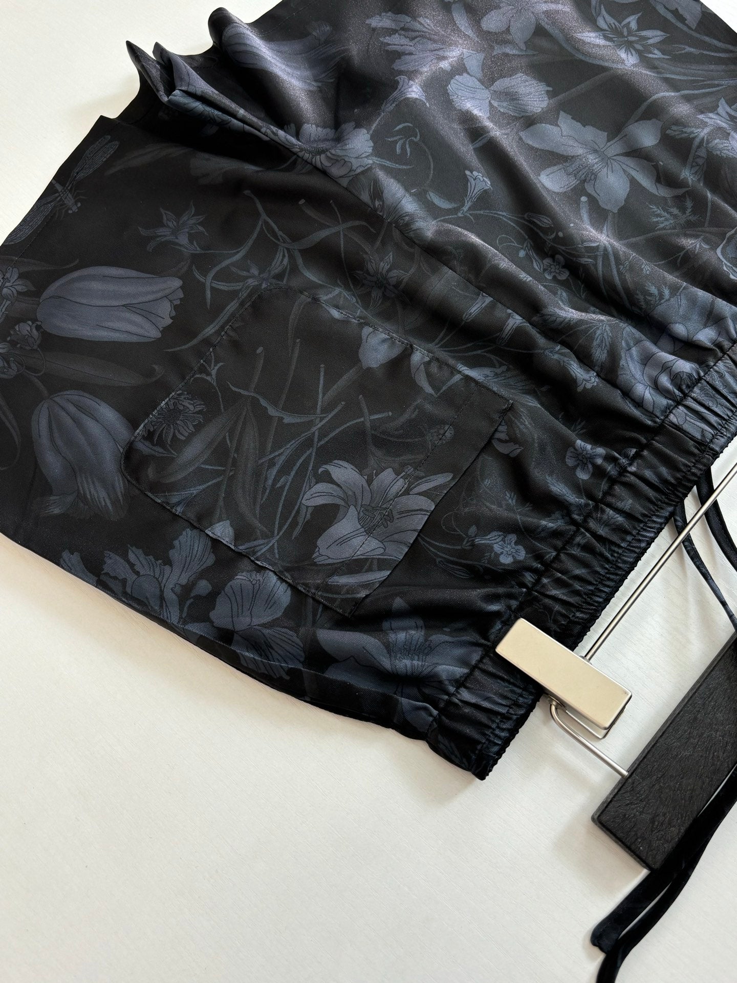 Gucci shorts fabric close-up, dark floral print with elastic cuff