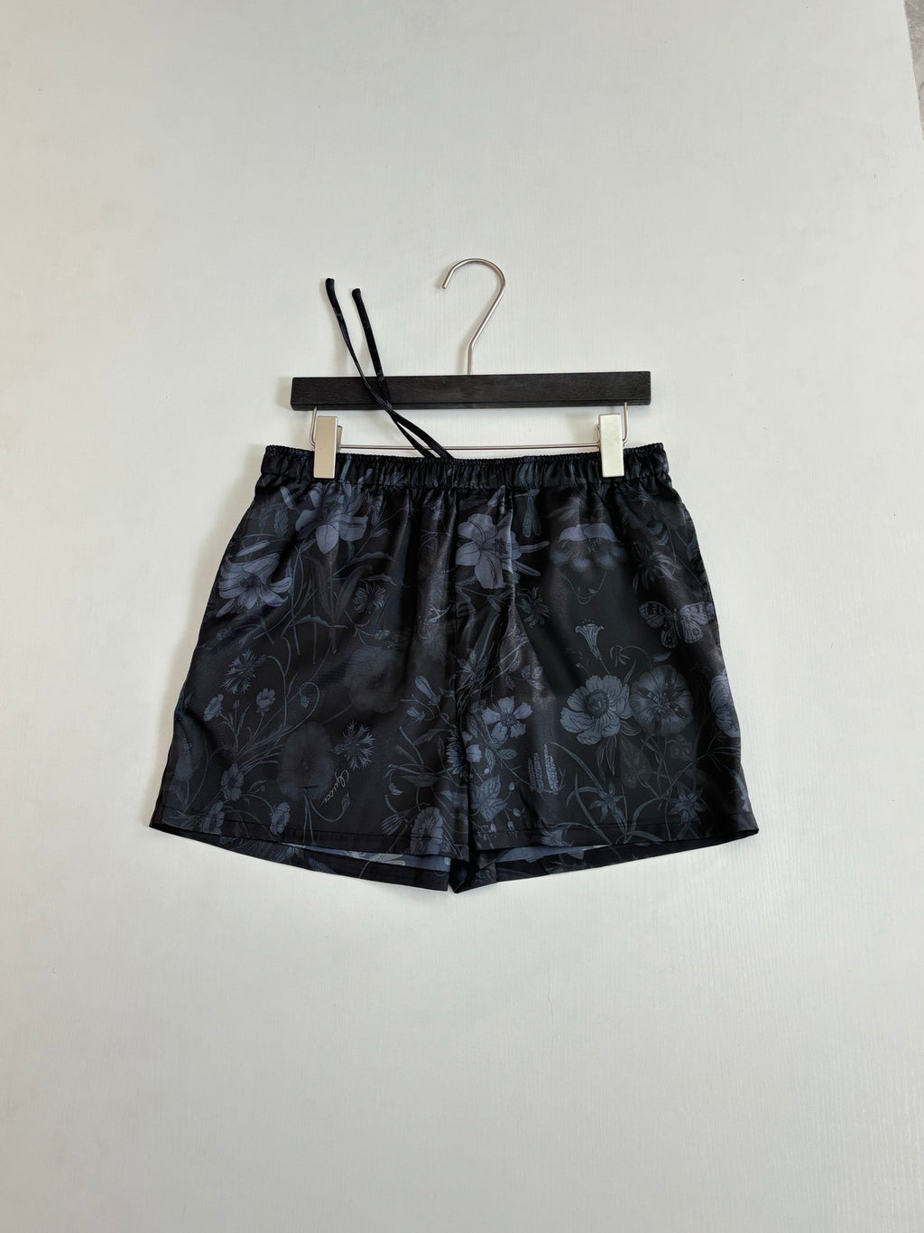 Gucci floral print shorts on hanger, dark fabric, elastic waistband