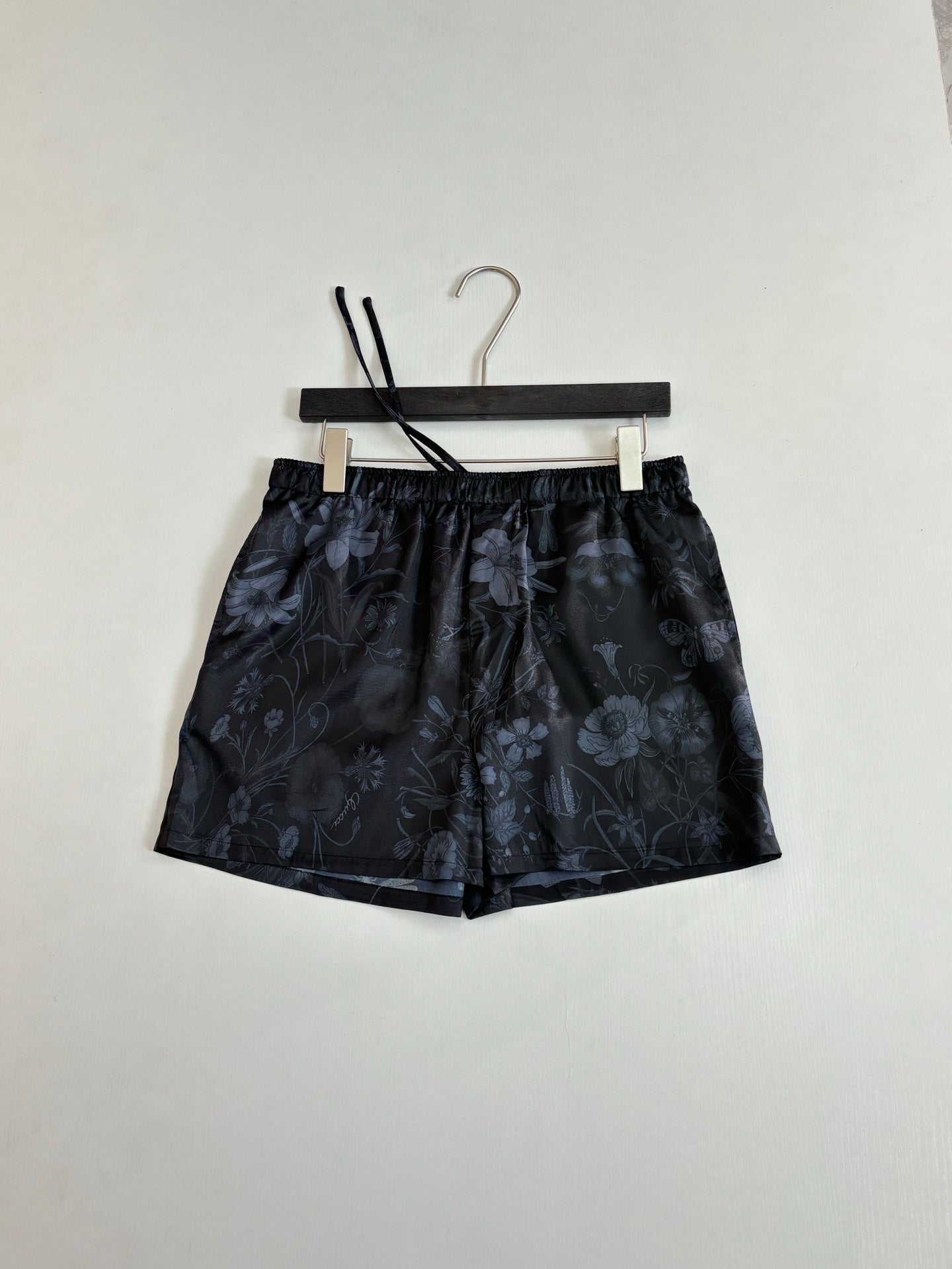 Gucci floral print shorts on hanger, dark fabric, elastic waistband