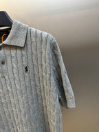 Light gray cable-knit polo shirt sleeve and side, textured knit and button placket
