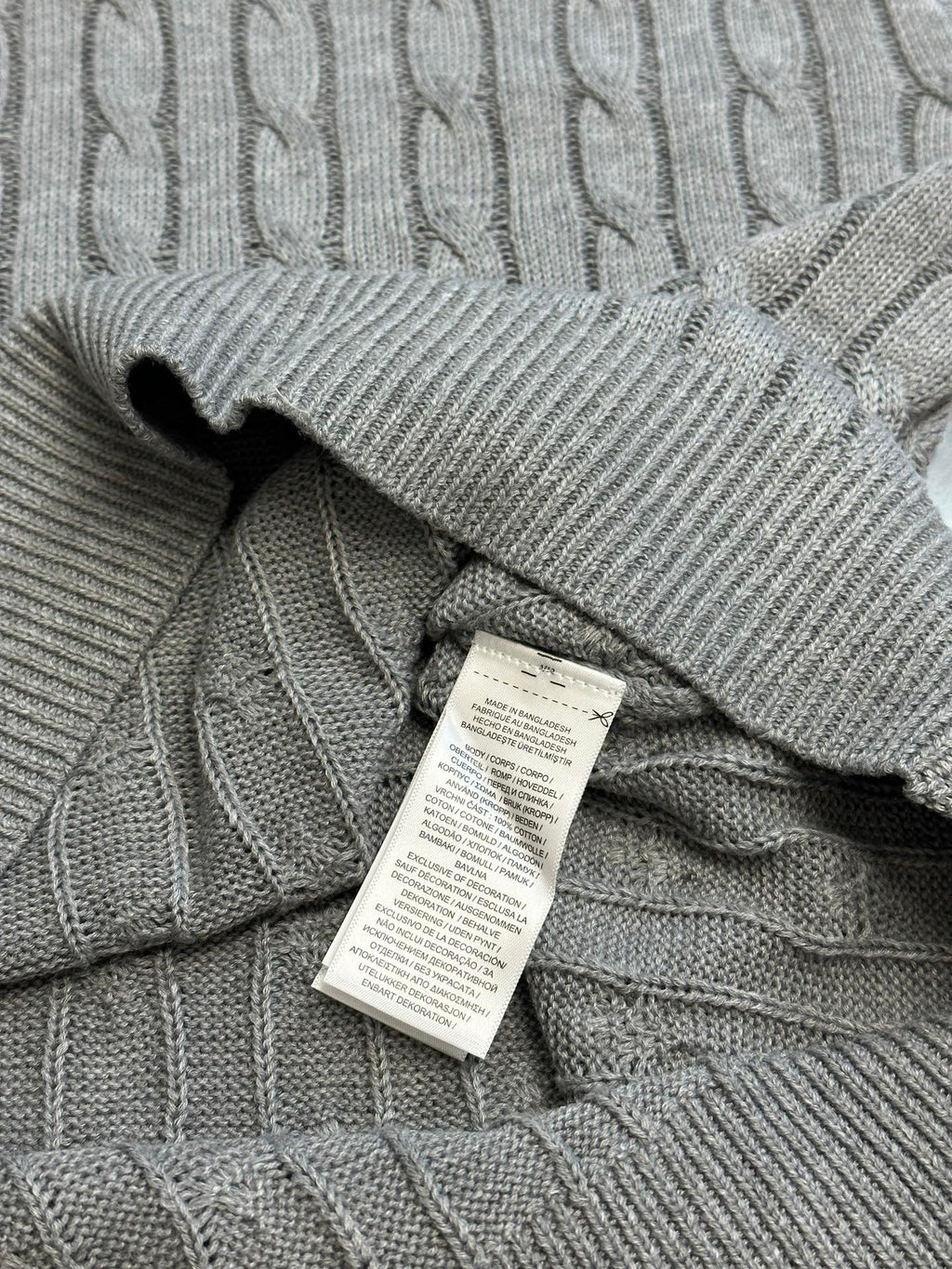 Light gray cable-knit polo collar with inside neck tag label