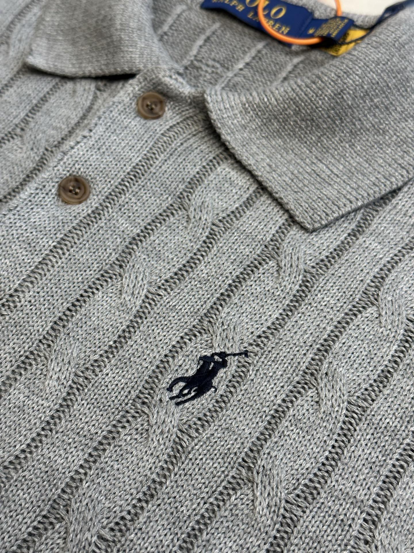 Light gray knitted polo front with small horse logo, three-button placket