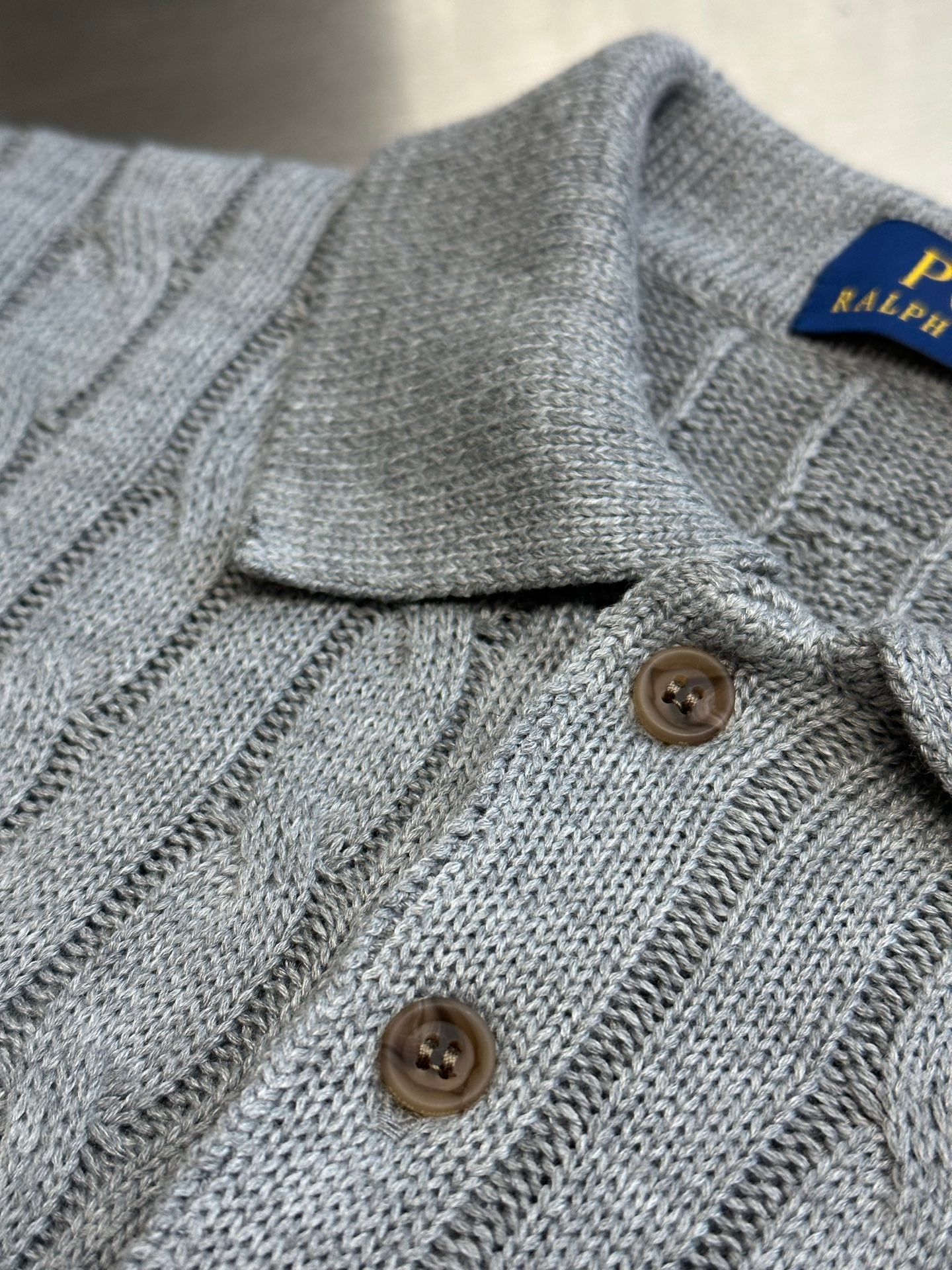 Light gray knitted polo shirt with ribbed collar and two-button placket detail