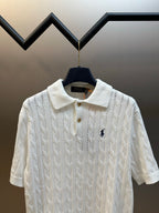 White knit polo shirt with spread collar, three-button placket, and navy pony logo.