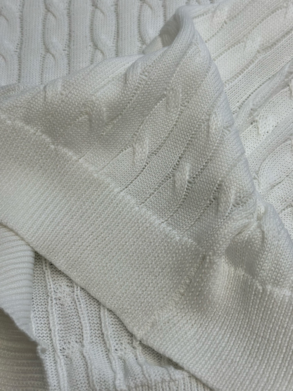 White knit polo sleeve and cable knit texture close-up.