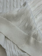 White knit polo sleeve and cable knit texture close-up.