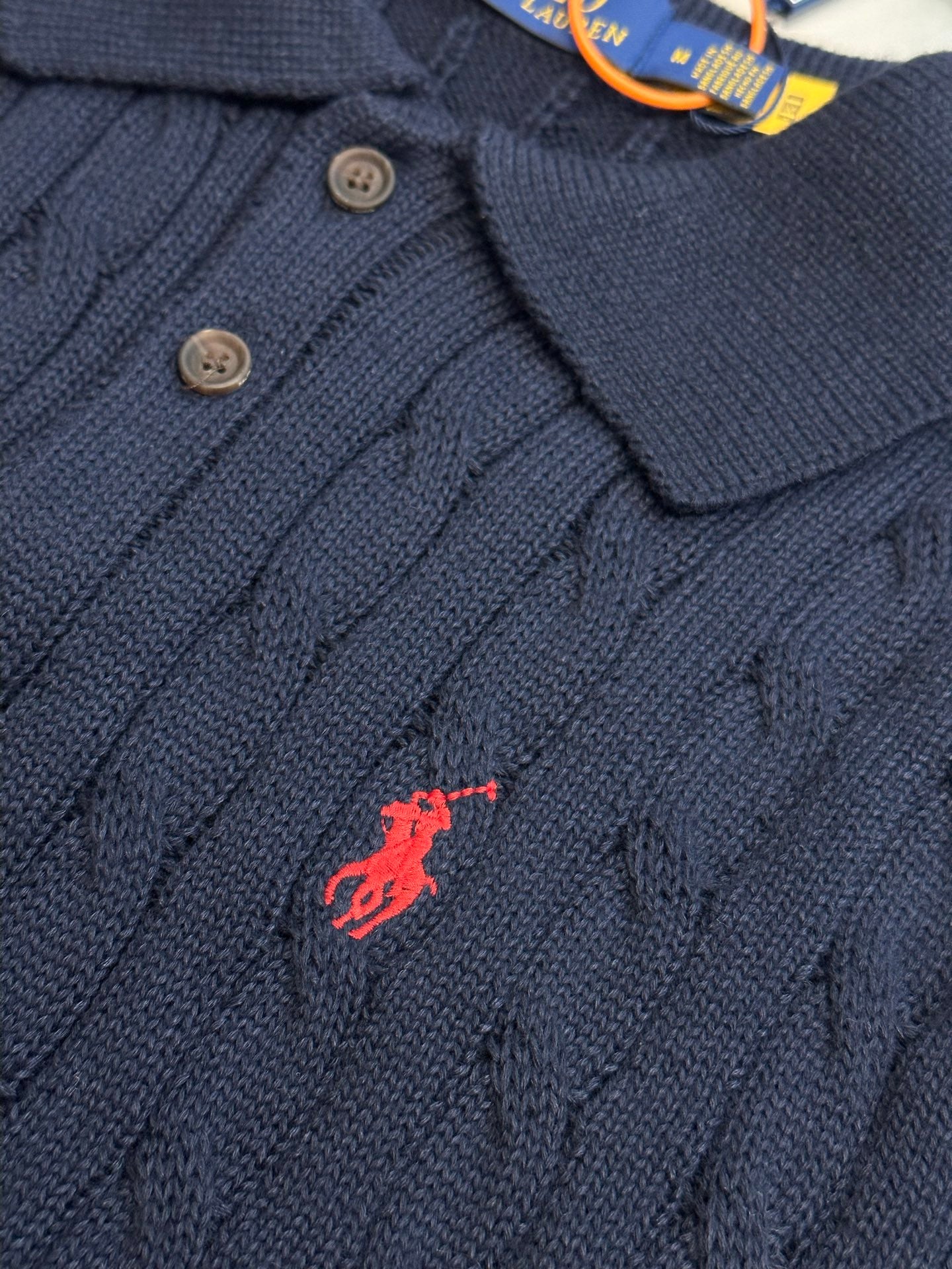 Navy knit polo shirt with dark buttons and embroidered red horse logo