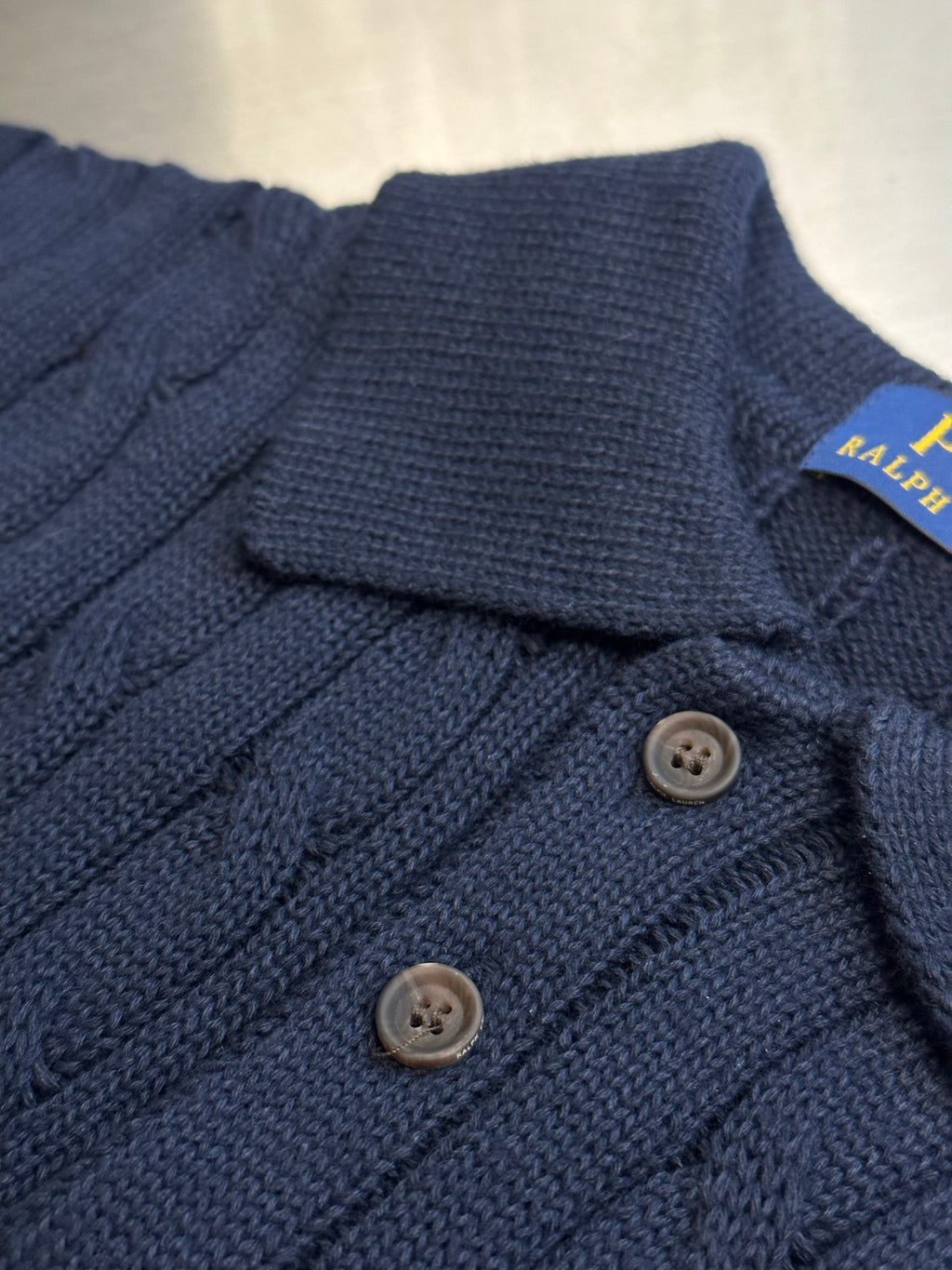 Navy knit polo shirt with ribbed collar and three button placket