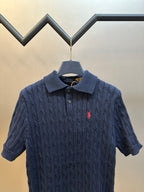 Navy knit polo shirt with spread collar, buttons, and small red horse logo