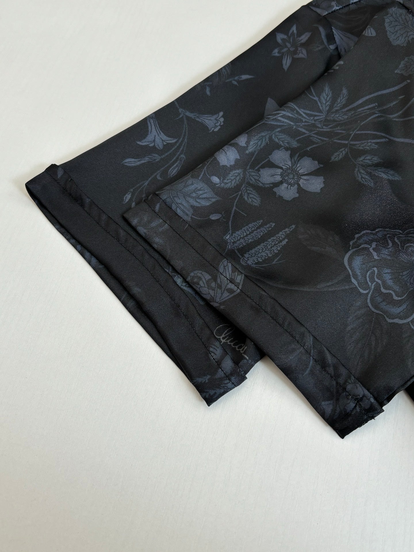 Gucci shorts front view, dark fabric with blue floral print