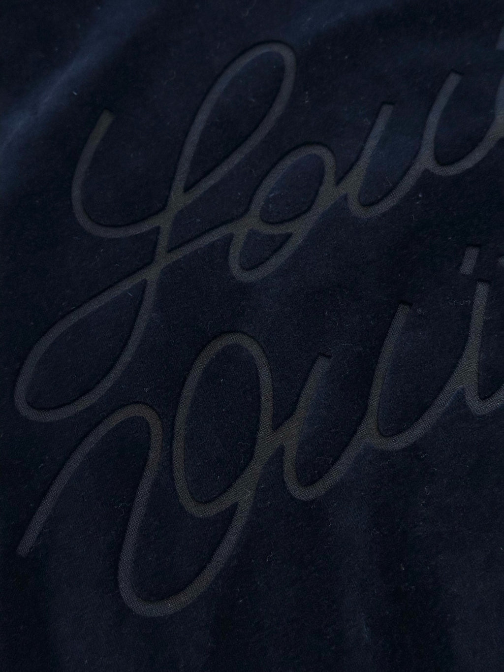 Navy jacket with subtle embossed script logo on back panel