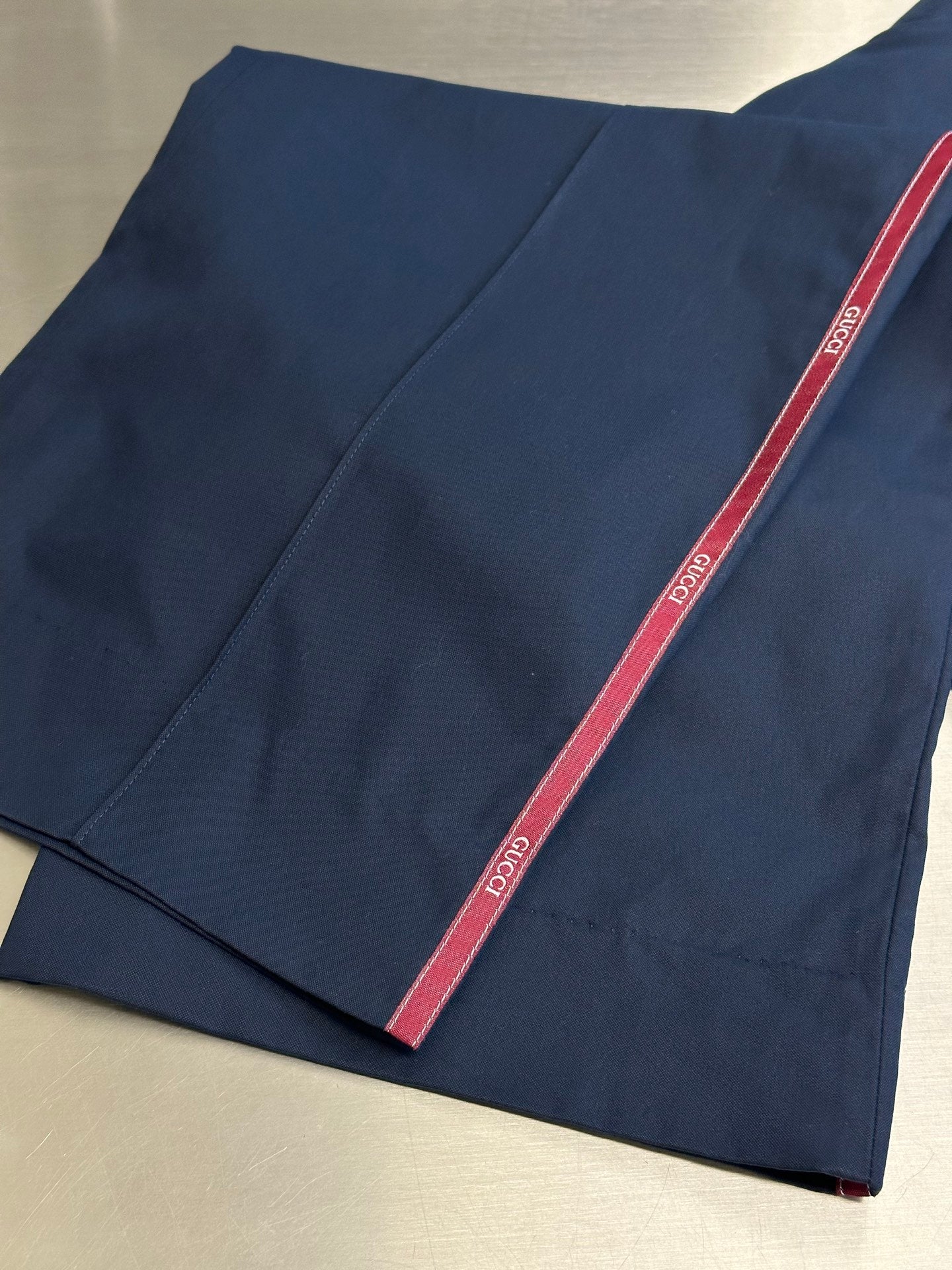 Navy pants with red side stripe, folded fabric view