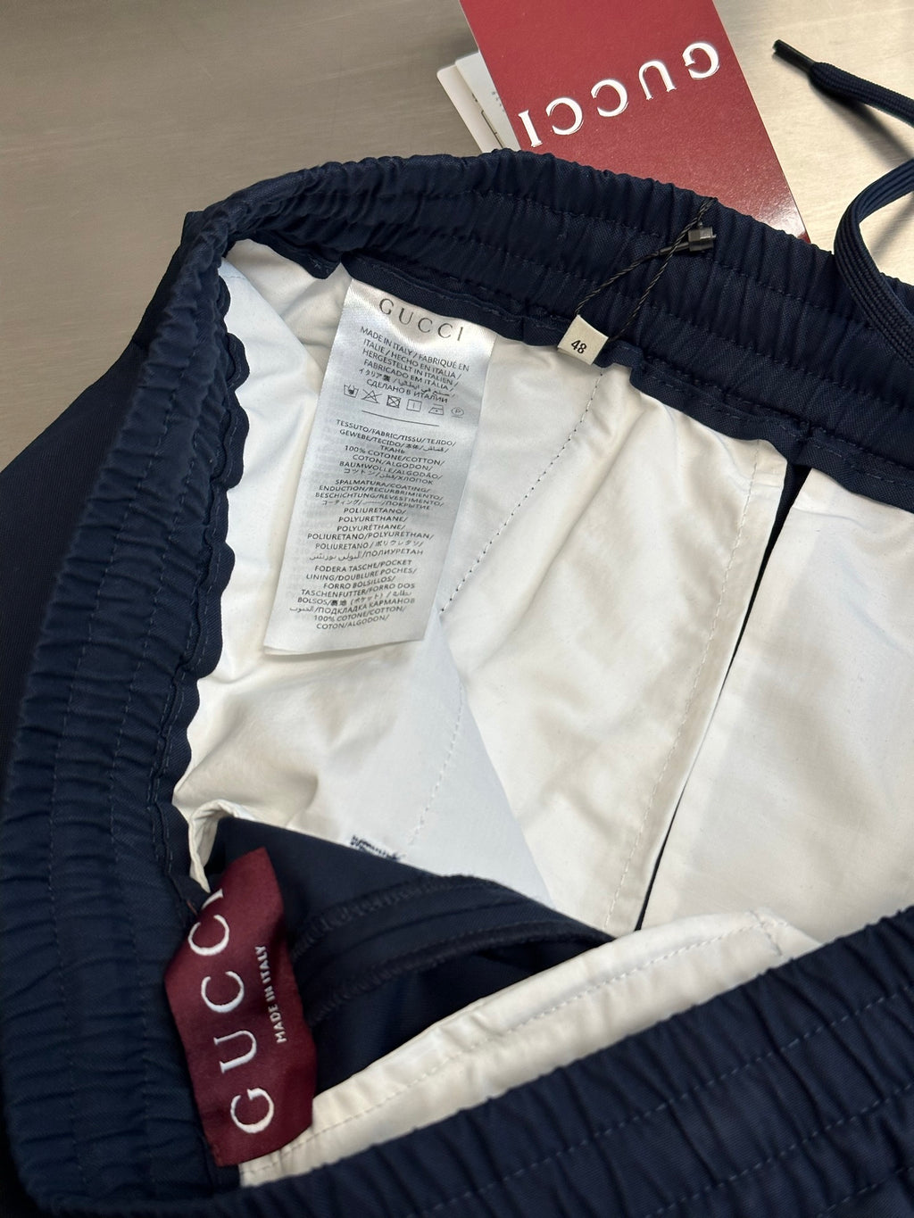 Navy pants interior with elastic waistband, tags, and white lining