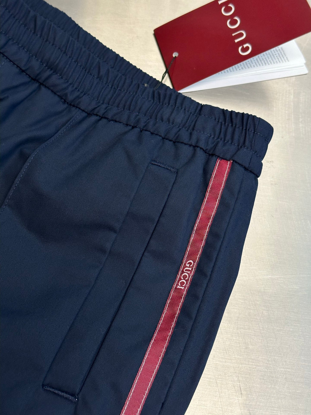Navy pants with elastic waistband and red-trim side stripe, cuff detail