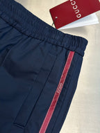 Navy pants with elastic waistband and red-trim side stripe, cuff detail
