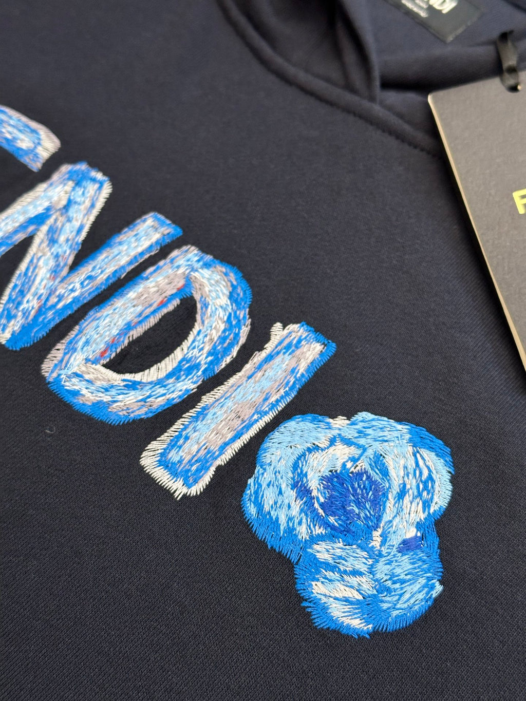 Navy hoodie close-up of embroidered blue FENDI logo letters
