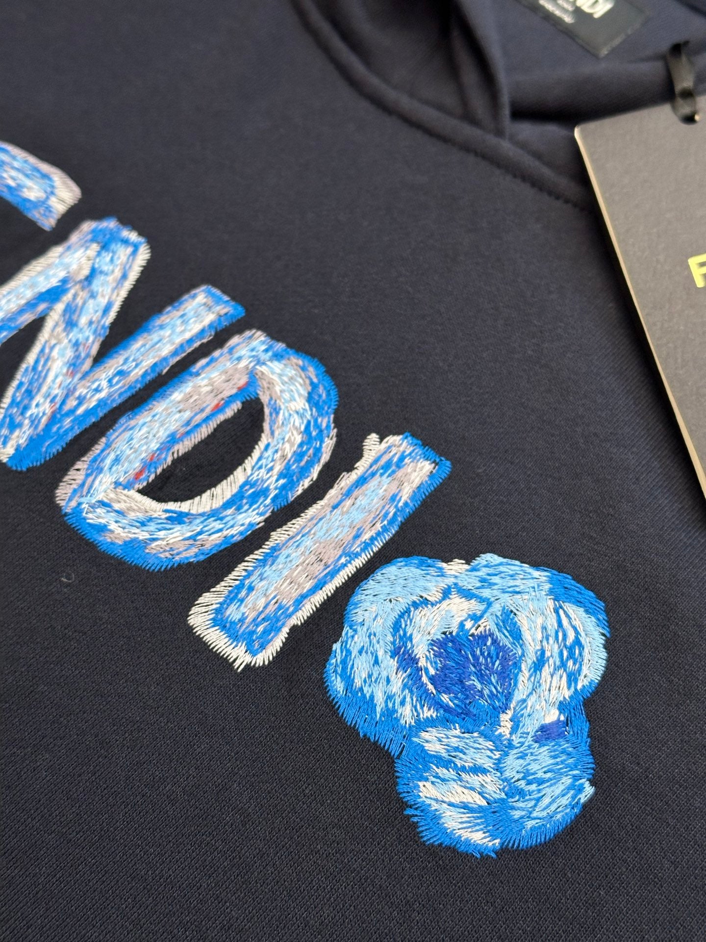 Navy hoodie close-up of embroidered blue FENDI logo letters