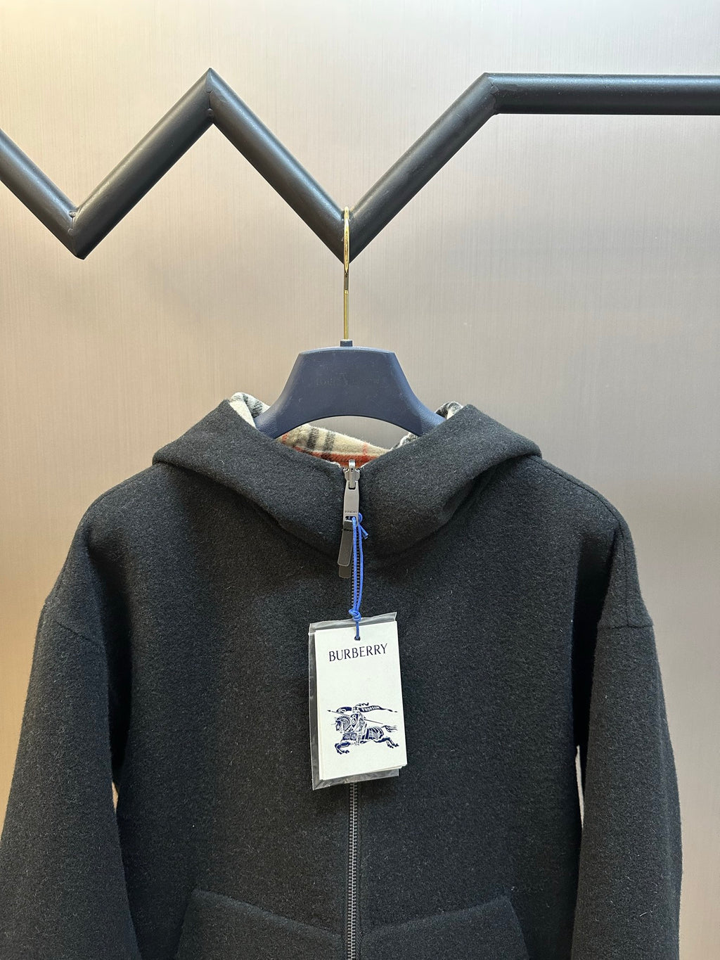Burberry hooded zip jacket close view, dark charcoal, blue zipper pull and label