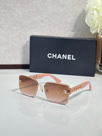 Chanel sunglasses with pink-tinted lenses and gold chain temple accents, square frames