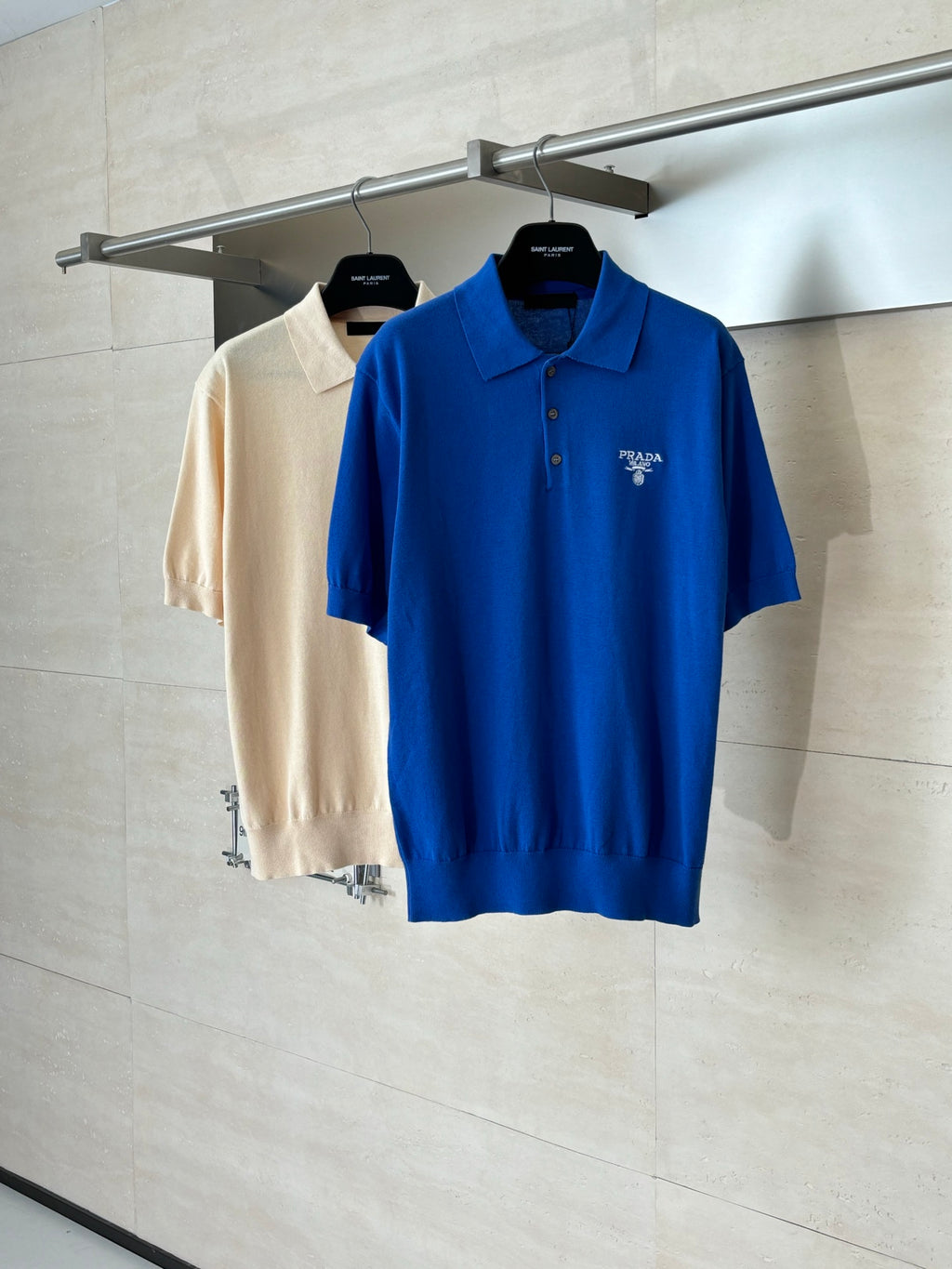 Blue and beige short-sleeve Prada polo shirts on hangers