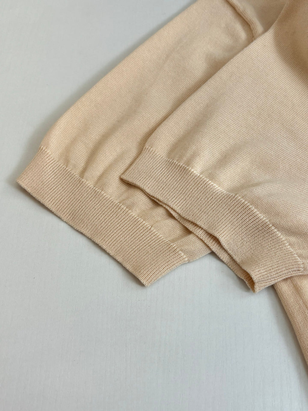 Beige polo shirt sleeve and cuff detail with ribbed knit trim