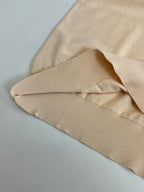 Beige polo shirt laid flat, showing ribbed collar and knit fabric texture